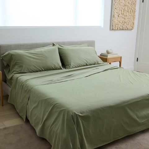 Bed made with the Sage green cooling sheets from Slumber Cloud